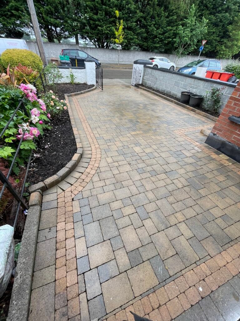 Clean block-paved driveway with weed-free joints and tidy planted borders